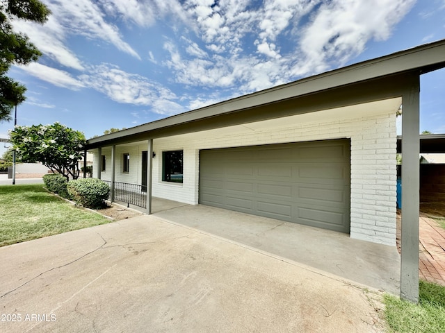 ranch-style house featuring a garage, concrete driveway, and brick siding