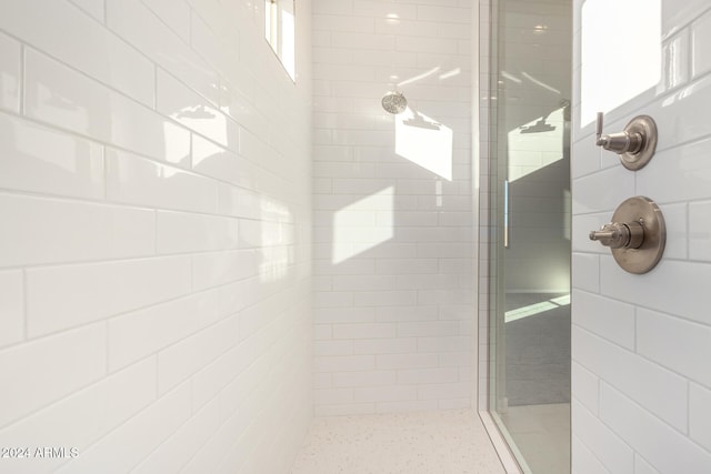 bathroom with a healthy amount of sunlight and a tile shower