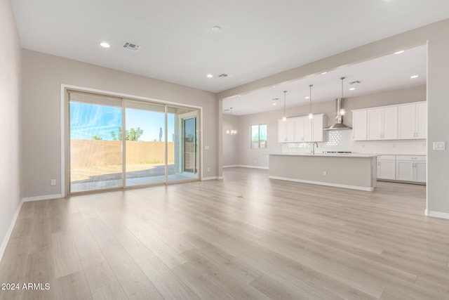 unfurnished living room featuring light hardwood / wood-style floors, a healthy amount of sunlight, and sink