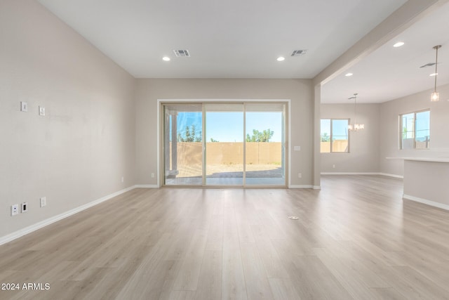 empty room featuring light hardwood / wood-style floors and a chandelier