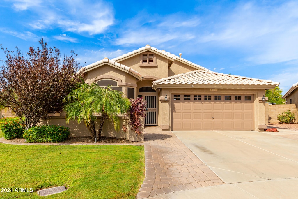 view of front of property with a front yard and a garage