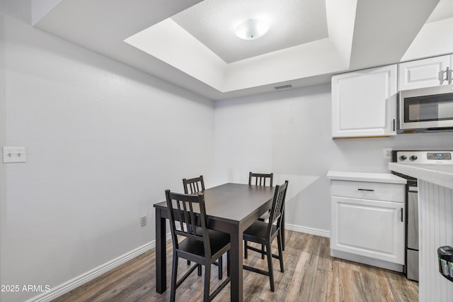 10610 S 48th St Unit 1096, Phoenix, AZ 85044 - dining space with a tray ceiling and wood finished floors