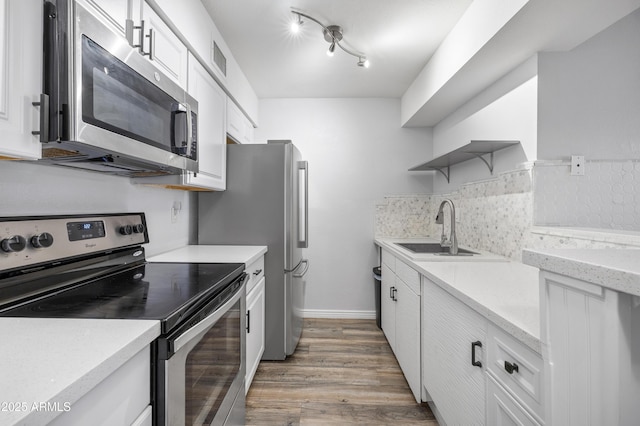 10610 S 48th St Unit 1096, Phoenix, AZ 85044 - kitchen with appliances with stainless steel finishes, open shelves, light wood-style floors, white cabinets, and tasteful backsplash
