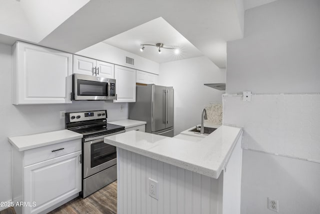 10610 S 48th St Unit 1096, Phoenix, AZ 85044 - kitchen featuring stainless steel appliances, white cabinets, a peninsula, dark wood-style floors, and light stone counters