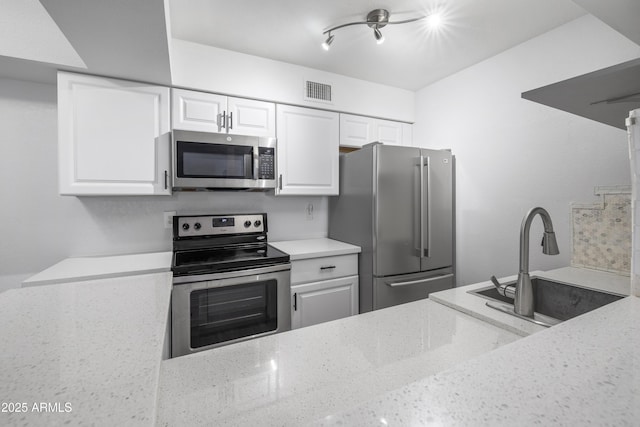 10610 S 48th St Unit 1096, Phoenix, AZ 85044 - kitchen with appliances with stainless steel finishes, light stone countertops, and white cabinetry