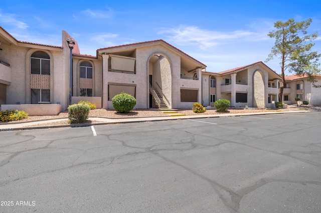 10610 S 48th St Unit 1096, Phoenix, AZ 85044 - view of front of home featuring uncovered parking, a tile roof, stucco siding, and stairs