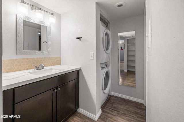 10610 S 48th St Unit 1096, Phoenix, AZ 85044 - bathroom featuring stacked washer and clothes dryer, wood finished floors, vanity, and backsplash