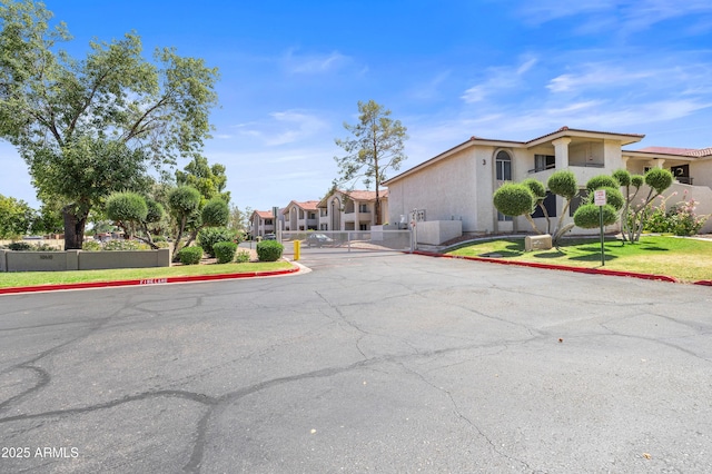 10610 S 48th St Unit 1096, Phoenix, AZ 85044 - view of asphalt road with a gate, curbs, and traffic signs
