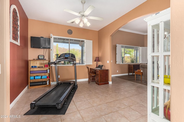 workout area with light tile patterned floors, a wealth of natural light, ornamental molding, and ceiling fan