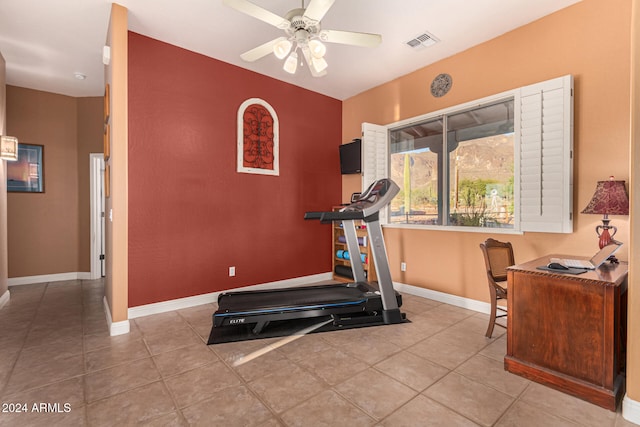 workout room with ceiling fan and light tile patterned floors