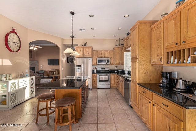 kitchen featuring ceiling fan, sink, decorative light fixtures, light tile patterned floors, and appliances with stainless steel finishes