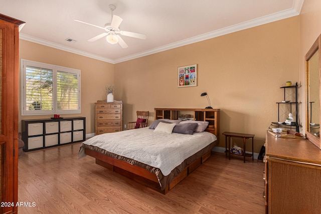 bedroom featuring ceiling fan, ornamental molding, and light hardwood / wood-style flooring