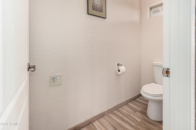 bathroom featuring hardwood / wood-style flooring and toilet