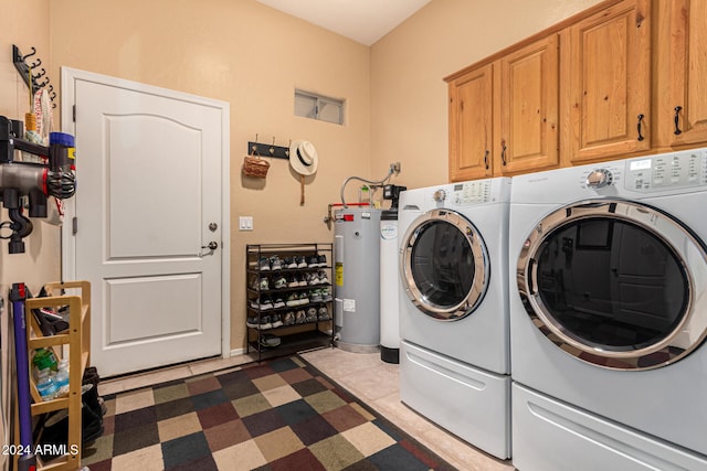 washroom with washing machine and clothes dryer, electric water heater, light tile patterned floors, and cabinets