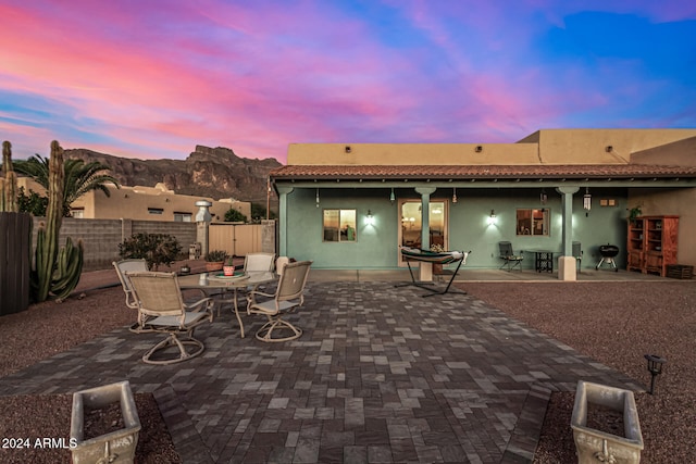 patio terrace at dusk featuring a mountain view