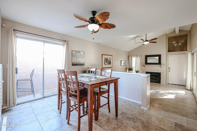 dining area featuring a fireplace, plenty of natural light, lofted ceiling, and ceiling fan