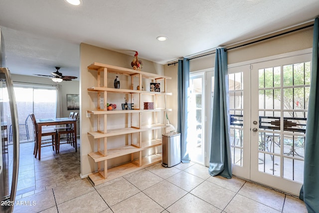 entryway with ceiling fan, a water view, and a textured ceiling