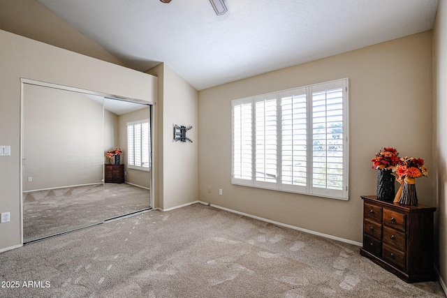 carpeted bedroom with lofted ceiling and a closet