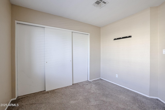 unfurnished bedroom featuring carpet floors and a closet