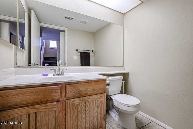 bathroom with tile patterned flooring, vanity, and toilet