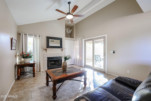 living room featuring ceiling fan, lofted ceiling, and a tile fireplace