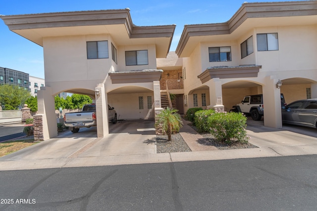 3235 E Camelback Rd Unit 124, Phoenix, AZ 85018 - view of front of property with stucco siding, stairs, and a carport