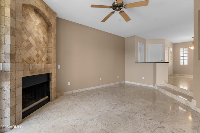 3235 E Camelback Rd Unit 124, Phoenix, AZ 85018 - unfurnished living room featuring a ceiling fan, baseboards, and a fireplace
