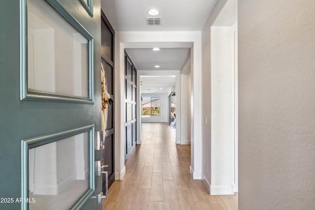 hallway with light hardwood / wood-style floors