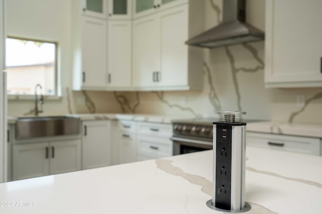 kitchen featuring white cabinets, wall chimney exhaust hood, electric stove, and sink