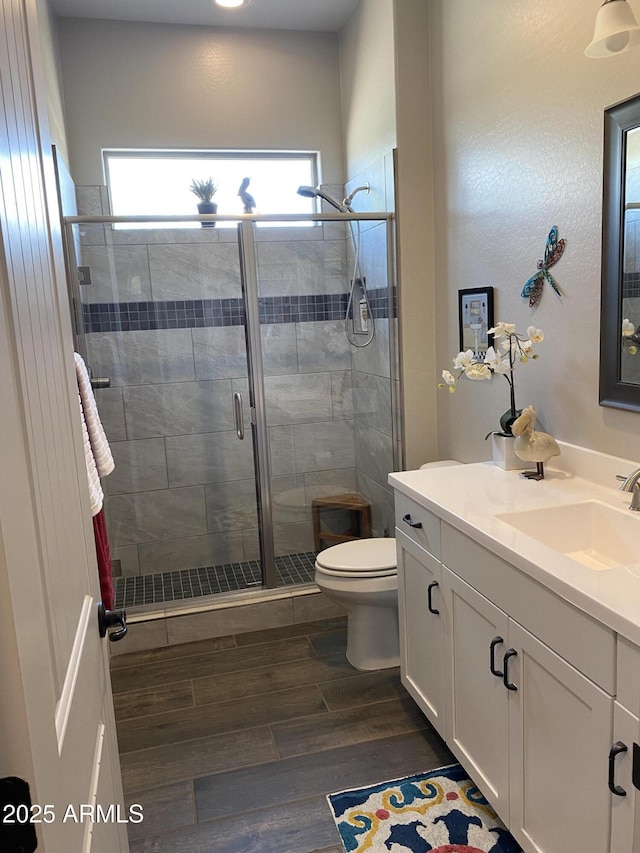 4114 Copperhead Dr, Wickenburg, AZ 85390 - bathroom featuring wood finished floors, vanity, toilet, and a stall shower