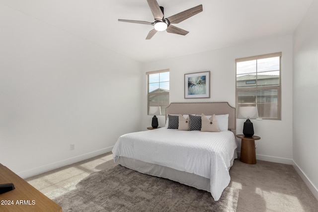 bedroom featuring multiple windows, ceiling fan, and light carpet