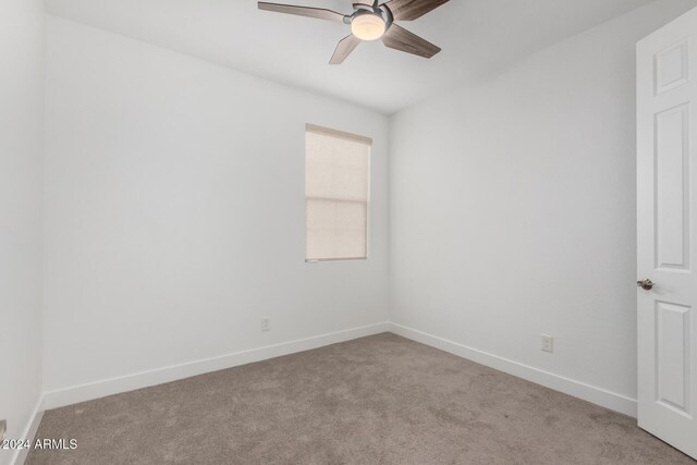 carpeted spare room featuring ceiling fan