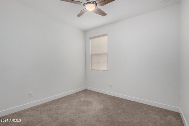 spare room featuring carpet and ceiling fan