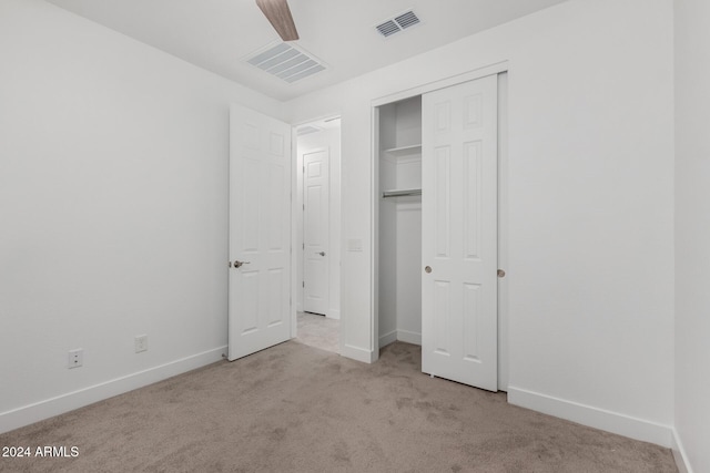 unfurnished bedroom with ceiling fan, a closet, and light carpet