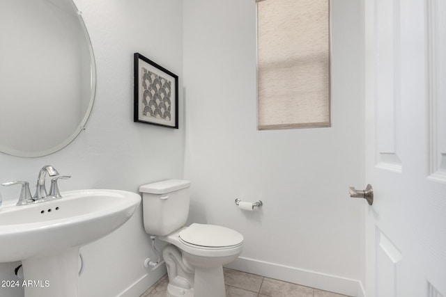 bathroom with toilet, tile patterned floors, and sink