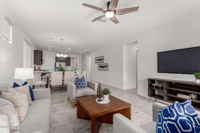 living room featuring light tile patterned floors and ceiling fan with notable chandelier