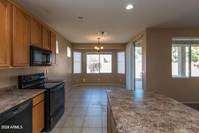 kitchen with a notable chandelier, a healthy amount of sunlight, light tile patterned floors, and black appliances