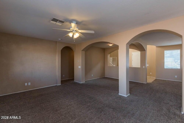 spare room with ceiling fan and dark carpet