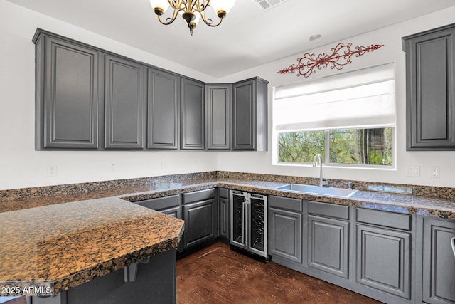 6310 E Dove Valley Rd, Cave Creek, AZ 85331 - kitchen with wine cooler, a chandelier, tile counters, gray cabinets, and dark wood-type flooring