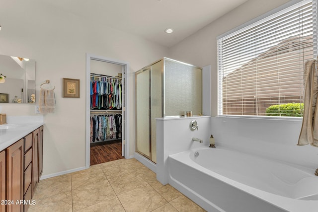 bathroom featuring tile patterned flooring, shower with separate bathtub, and vanity