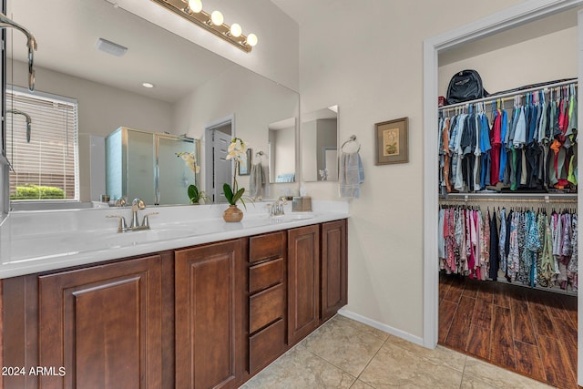 bathroom with vanity, a shower with door, and tile patterned floors