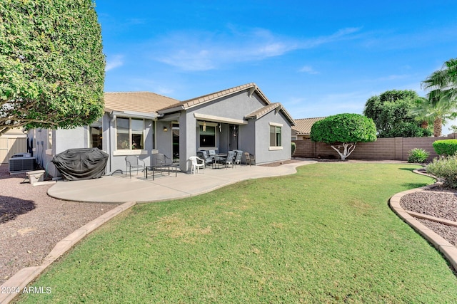 rear view of property featuring a patio, a yard, and cooling unit