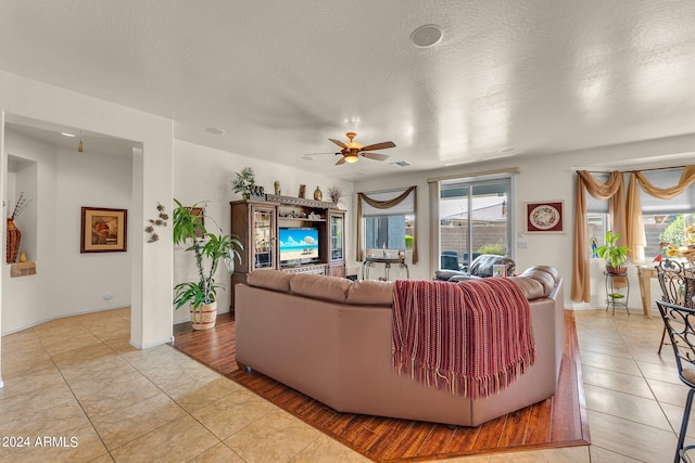 tiled living room featuring ceiling fan and a textured ceiling