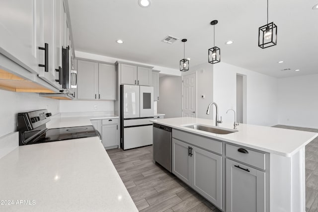 kitchen featuring visible vents, gray cabinets, stainless steel appliances, light countertops, and a sink