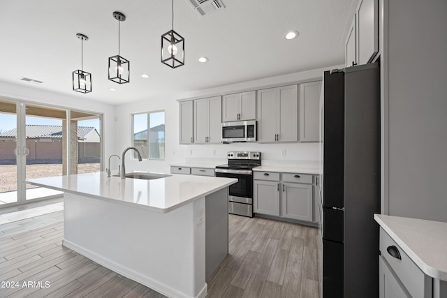 kitchen featuring stainless steel appliances, gray cabinets, visible vents, and a sink