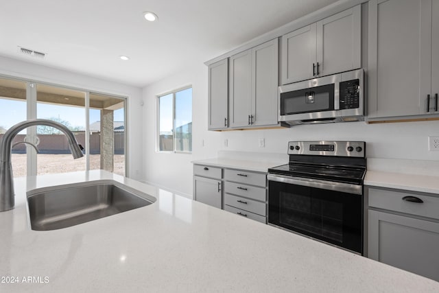 kitchen with recessed lighting, gray cabinetry, a sink, visible vents, and appliances with stainless steel finishes