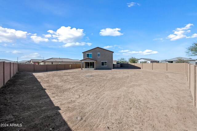 back of house featuring a fenced backyard and stucco siding