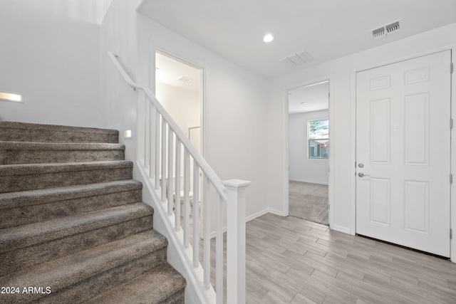 staircase with recessed lighting, wood finished floors, visible vents, and baseboards