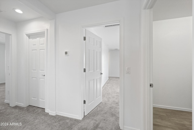 hall featuring carpet flooring and baseboards