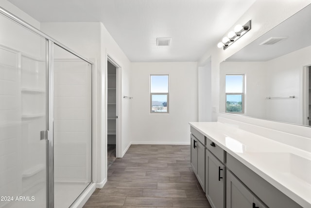 bathroom featuring a stall shower, a wealth of natural light, visible vents, and vanity